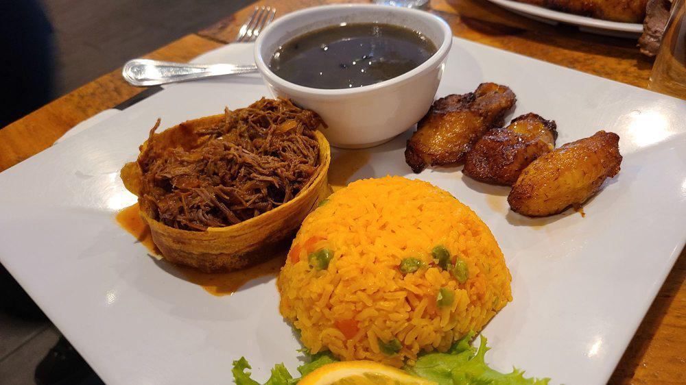 Ropa Vieja · Cuban style shredded beef served with yellow rice, sweet plantain & black beans