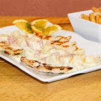 Pechuga En Crema De Piña · Grilled chicken breast topped with pineapple sauce & ham served with salad rice & fries