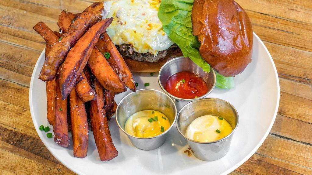 Raclette Burger · Six ounce sirloin patty, caramelized onions, lettuce and tomato on toasted brioche bun, served with sweet potatoes fries
