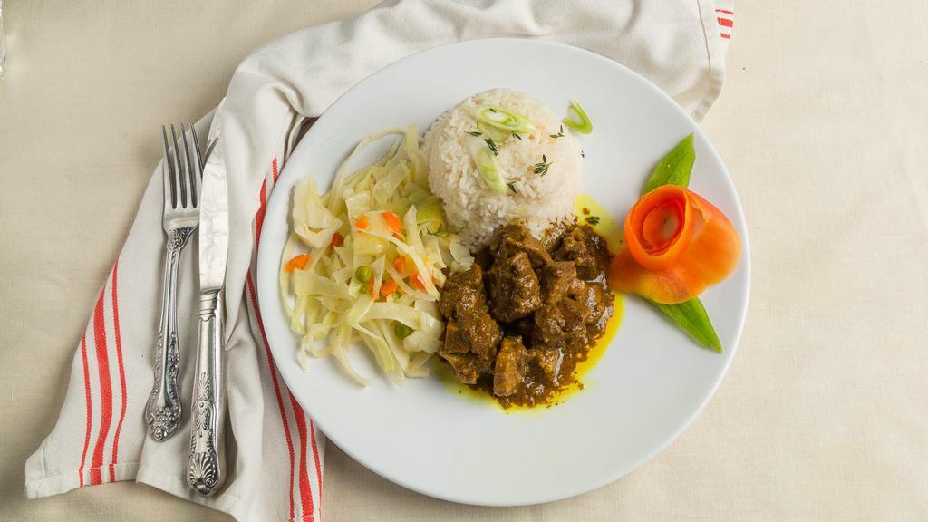 Curry Goat · Served with choice of side and steam veggie.