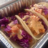 Fish Tacos · Three Fried fish tacos served with a spicy aioli sauce and raw cabbage.