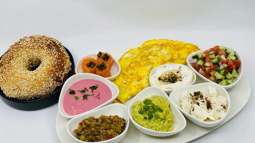 Israeli Breakfast · Eggs served with Israeli salad, smoked salmon, feta cheese, tahini, eggplant spread, kafteri, and labneh. Served with our house bread.
