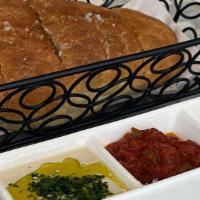 Accent Bread · Freshly baked frena bread in a taboon oven served with a three-dip, matbucha, tahini, and eg...