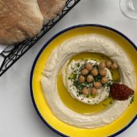 Classic Hummus · Homemade hummus with a side of pita, pickles, olives, and onion.