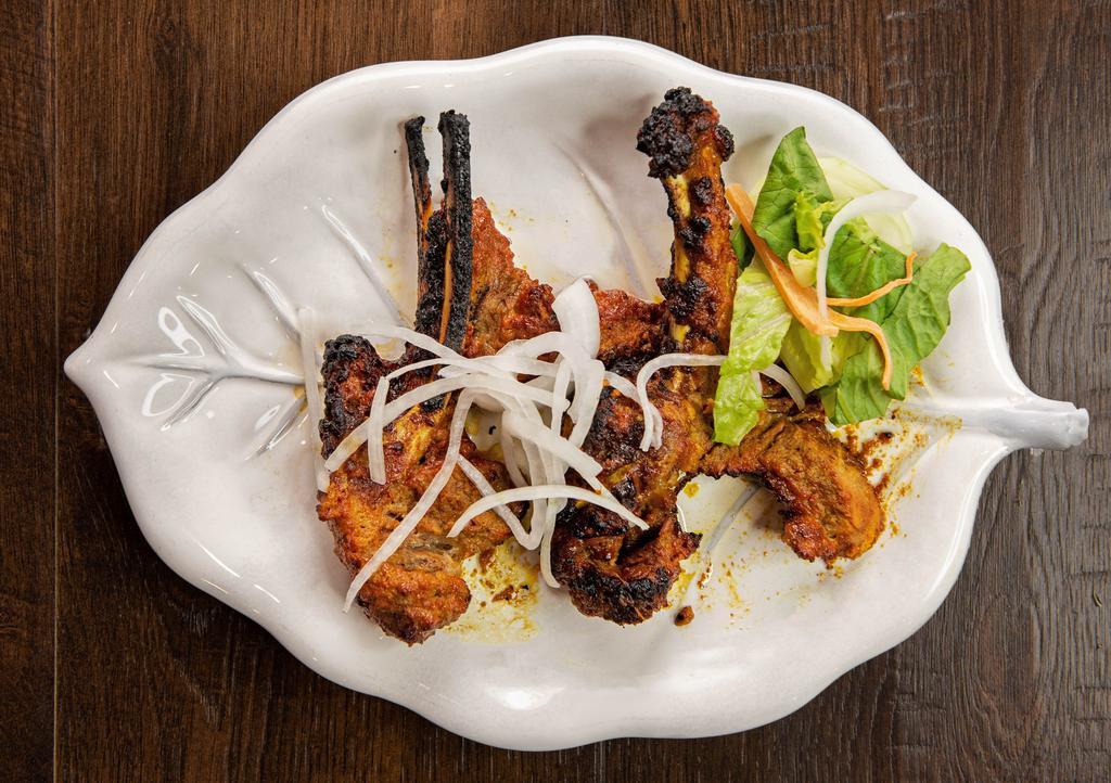 Lamb Chops · Three Pieces. Marinated lamb chops barbecued on a grill.