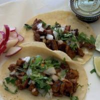 Steak Taco · One taco with onions and cilantro. Radish and lemon on the side.