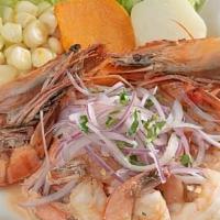 Ceviche De Camaron · Fresh shrimps marinated in lime juice; infused with red onions. Accompanied by Inca corn, po...