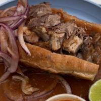 Carnitas Torta Ahogada · Birote baked on premises with carnitas, dipped in tomato sauce and chile de árbol, a classic...