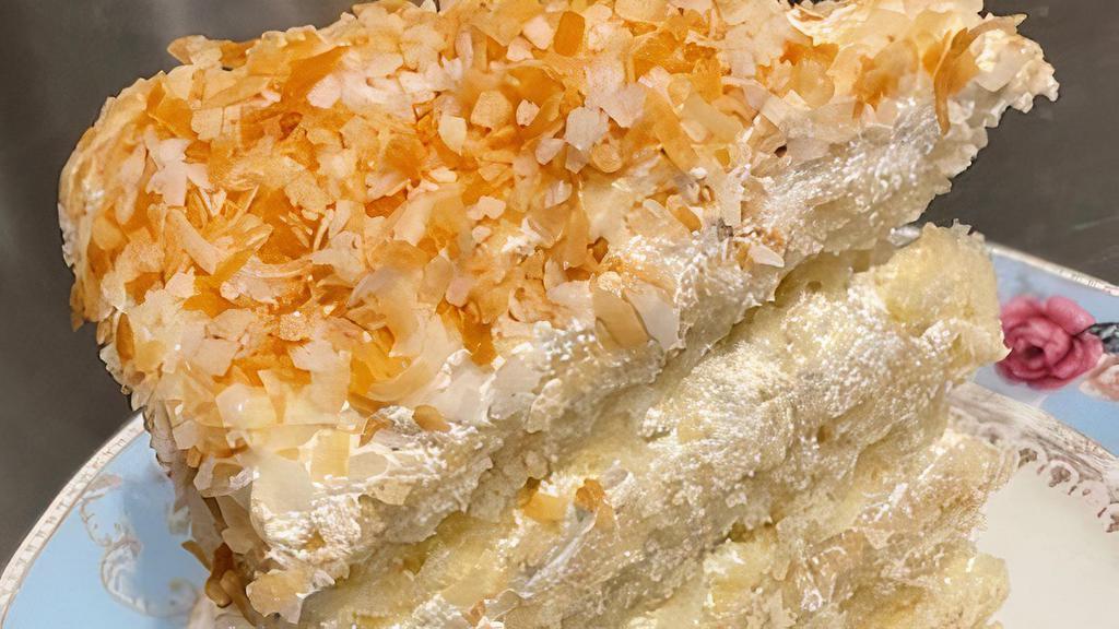 Toasted Coconut Custard Cake · Coconut with blanched almonds.  Finished with vanilla frosting, toasted coconut and almonds.
