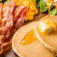 Grand Slam Pancakes · Two pancakes and syrup, served with a buttered bagel, two eggs any style, crispy bacon, and ...