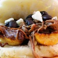 Arepa Pabellon · Ropa Vieja, Black Beans, Plantain & Avocado inside of a Flatbread made of ground corn patty ...