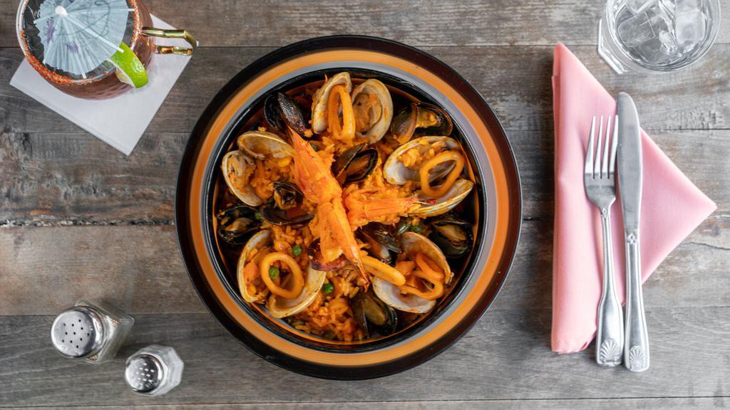 Paella Mariscada · Seafood paella with shrimp, scallops, clams, mussels, red snapper, chorizo español, calamari, saffron rice & mixed vegetables.