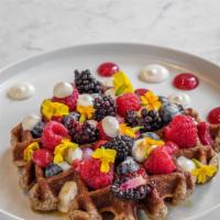 Paleo Banana Waffle (Gf) · Fluffy warm grain-free banana waffle, topped with coconut cream and blueberry compote. Glute...