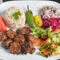 Lamb Shish Kebab · Chunks of marinated baby lamb grilled to de light on skewers served with rice and salad.