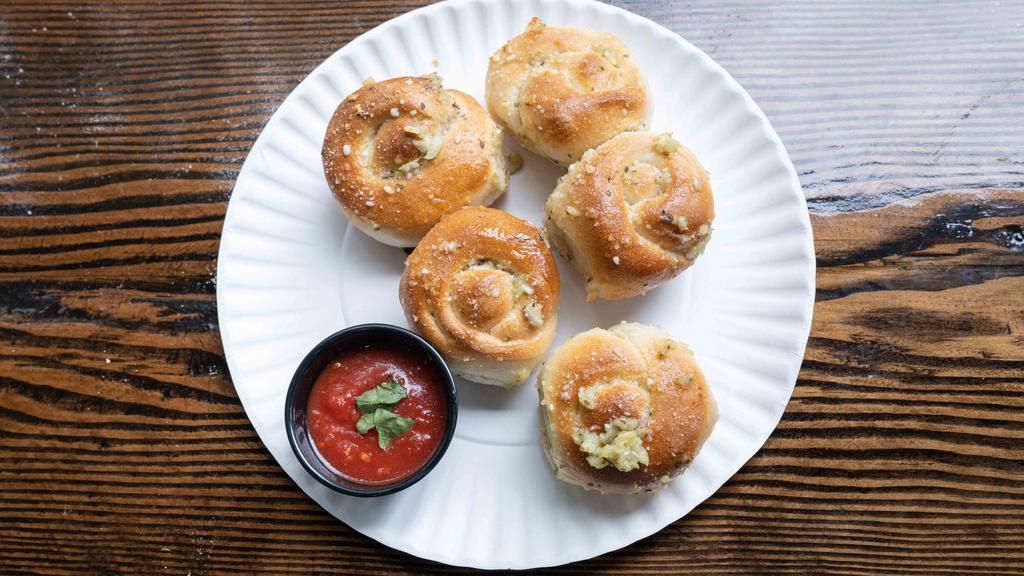 Garlic Knots · A classic snack, our garlic knots are strips of pizza dough tied in a knot, baked, and then topped with melted butter, garlic, and parsley.