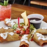 Steak Flautas · Filled with steak and cheese on top with black beans, lettuce, and cream.