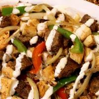 Lamb Gyro Over Rice · Chunks of lamb on rice with lettuce, tomato, onion, green peppers & gyro sauce.