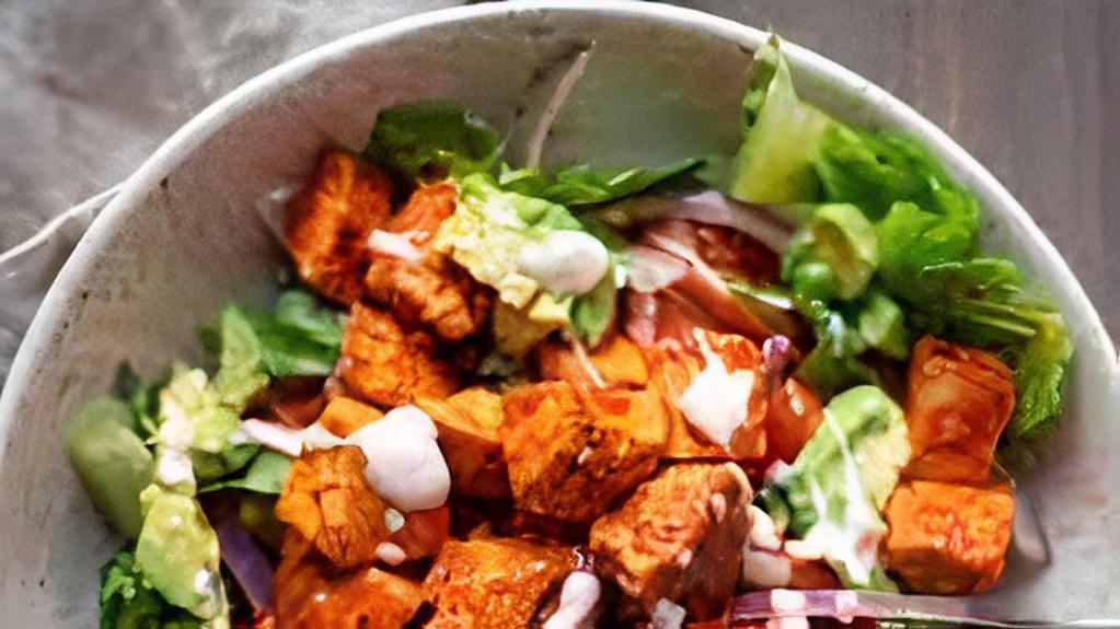 Buffalo Blue Chicken Salad · Lightly fried chicken tenders tossed in buffalo sauce over romaine and iceberg lettuce, in cool ranch dressing with diced tomatoes and crumbled bleu cheese in a tortilla bowl.