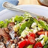 Steak House Salad · Sliced marinated steak atop mixed field greens loaded with diced tomato, crumbled bleu chees...