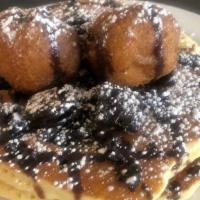 Fried Oreo Cakes · Oreo cookie mixed into pancakes topped with two fried oreos and drizzled with chocolate sauce