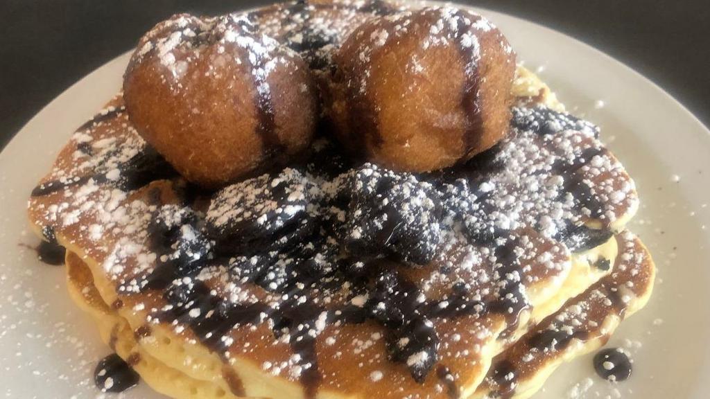 Fried Oreo Cakes · Oreo cookie mixed into pancakes topped with two fried oreos and drizzled with chocolate sauce