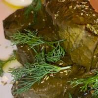 Dolmades · Hand rolled grape leaves stuffed with rice, dill and served with tzatziki.