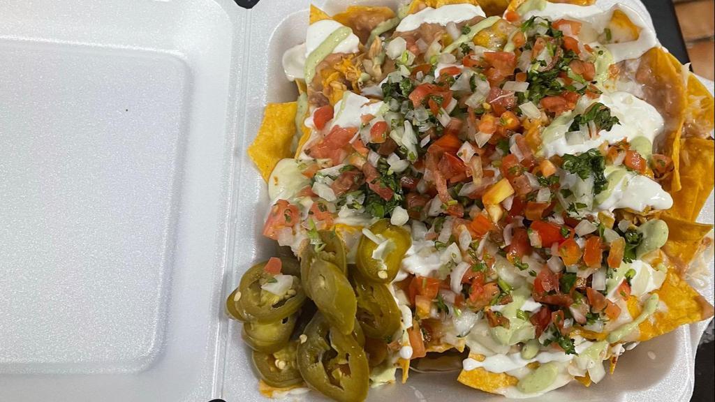 Ulitmate Nachos · Fried tortilla chips topped with your choice of protein, beans cheese , sour cream, jalapeños, and pico de Gallo,