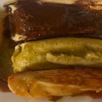 3 Corn Husk Tamales · 3 corn husk tamales with chicken and cheese with red green and mole sauce on top