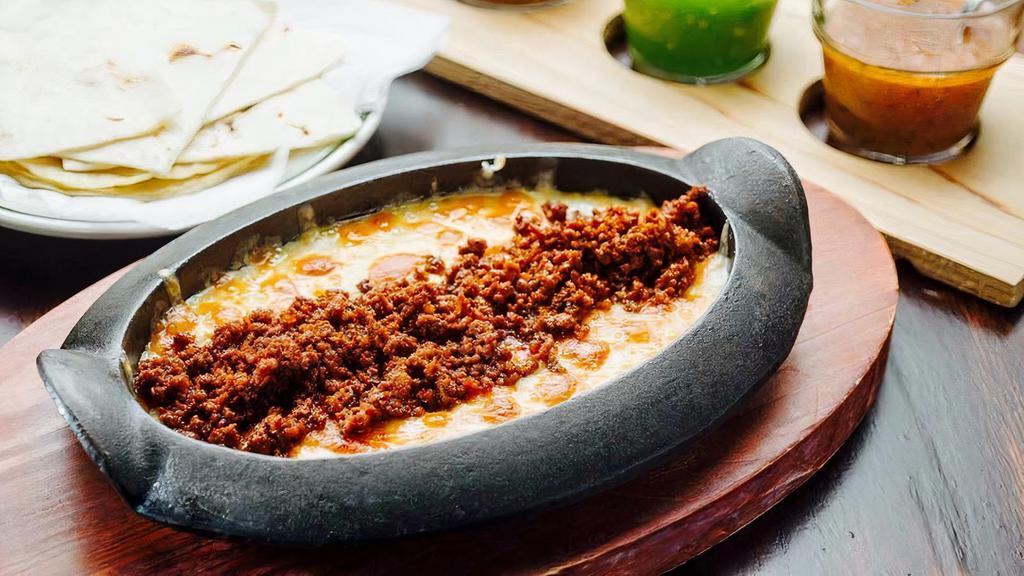 Queso Fundido · Mexican melted cheese (house blend); choice of homemade chorizo or mushrooms al epazote, corn, and flour tortillas.