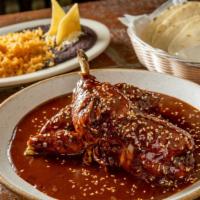 Pollo Con Mole Poblano · Roasted  chicken in “chef Ivan's traditional mole poblano” topped with sesame seeds, handmad...