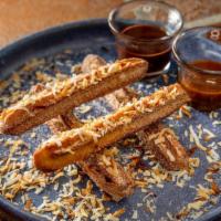 Coconut Churros · With caramel and chocolate sauces.