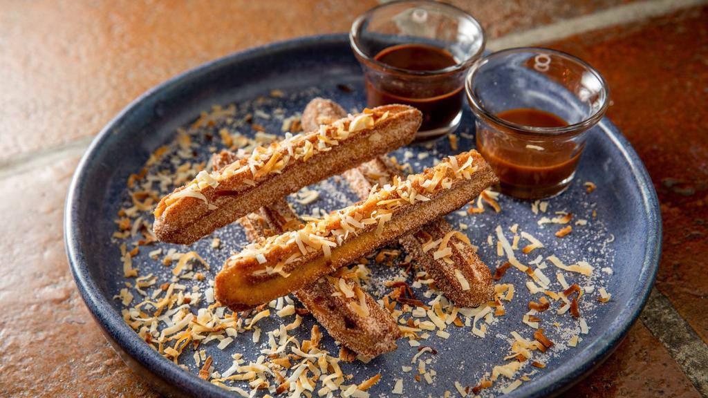 Coconut Churros · With caramel and chocolate sauces.