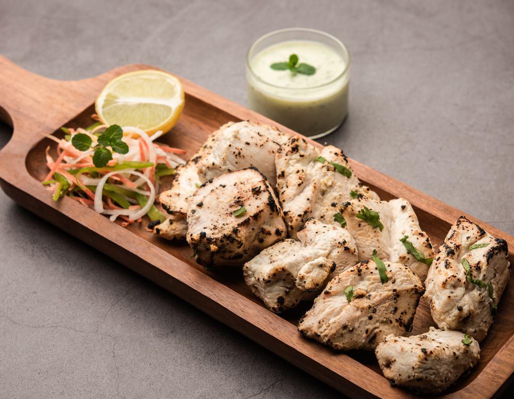 Chicken Malai Kebab · Boneless pieces of chicken breast marinated in cream cheese and spices. Skewered and broiled in the tandoor (clay oven).