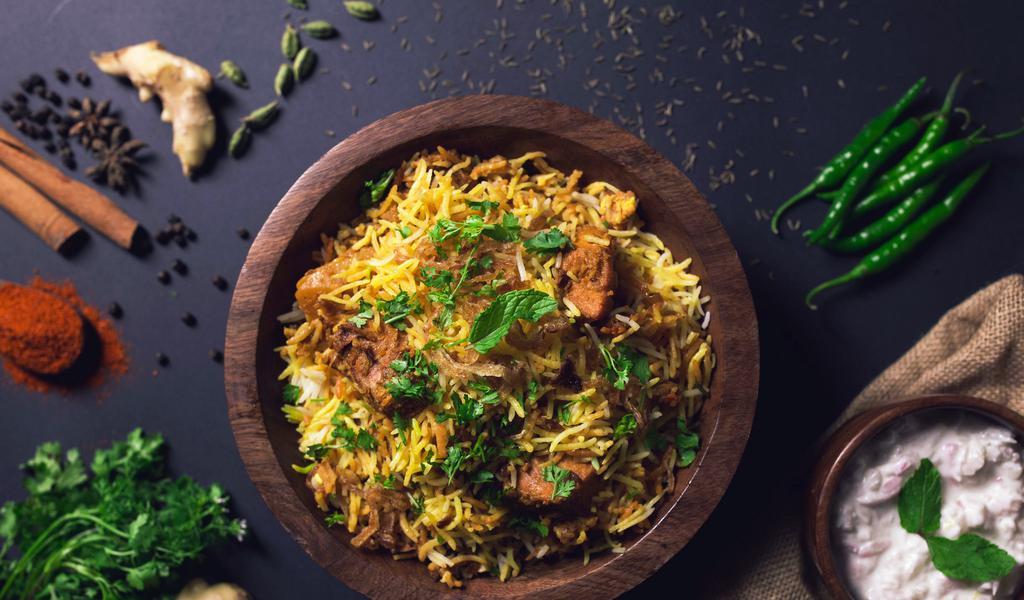 Vegetable Biryani · Include basmati rice sauteed with red onions, multi color bell pepper, broccoli, herbs, spices and garnished with nuts and raisins.