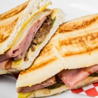 Cuban Sandwich · Sliced pork, pickles, ham, Swiss cheese and mayo on a garlic hero, with French fries.