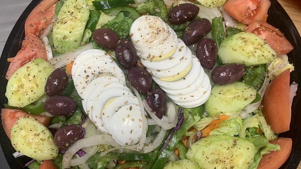 Family Garden Salad · Mixed greens, red cabbage, cucumbers, carrots, tomatoes, onions, green peppers, kalamata olives, hard-boiled eggs and spices. Served with a fresh roll.