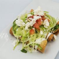 Taquitos Dorados (Order Of 4) · Deep-fried corn tortillas rolled and filled with chicken or or cheese-potato, topped with le...