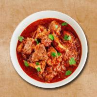 Lamb Maverick · Tender lamb pieces cooked in curry with chopped onions, tomatoes, and spices, topped with ci...
