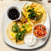 Huevos Rancheros Scramble · Lightly fried eggs served on a warm tortilla and topped with salsa, tomatoes, chili peppers,...