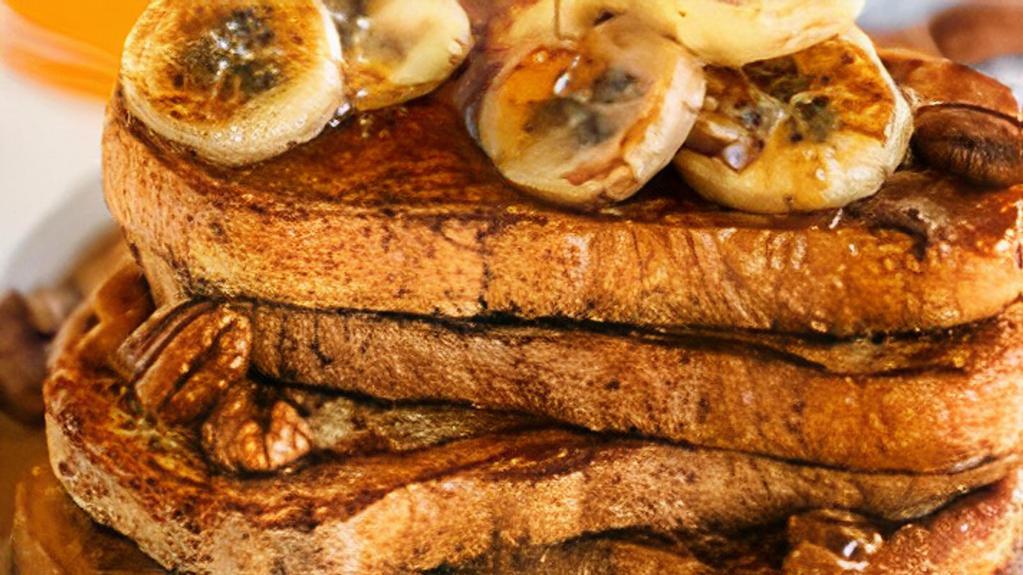Banana French Toast · Fresh bread battered in egg, milk, and cinnamon cooked until spongy and golden brown. Topped with powdered sugar, sliced bananas, and served maple syrup.