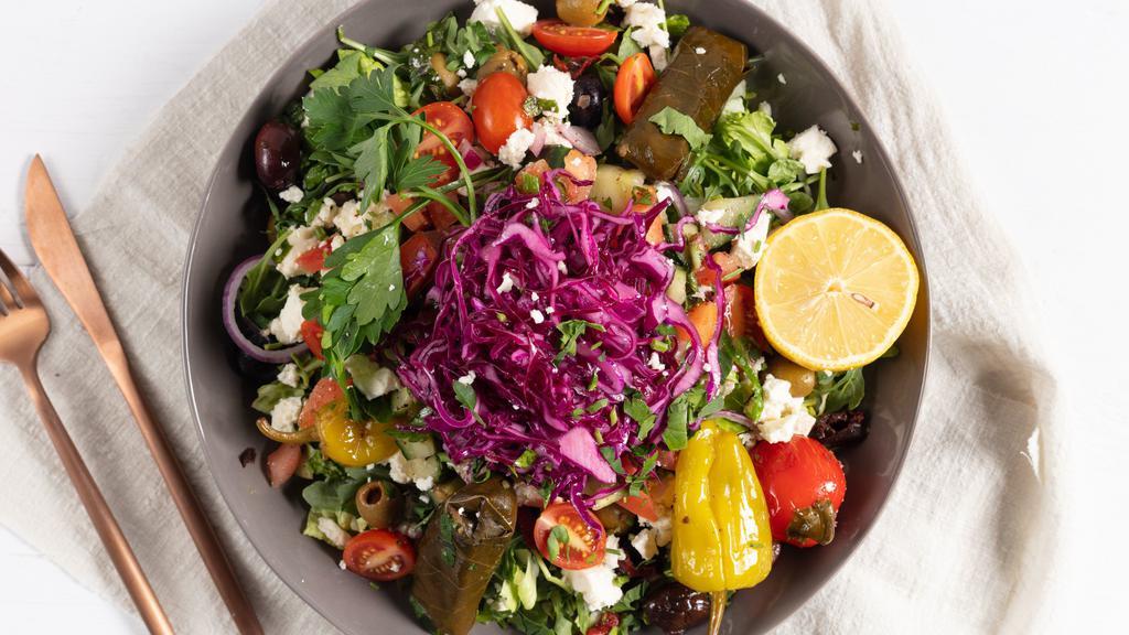 Greek Salad · Tomato, feta cheese, olives, onion, cucumber, red cabbage and stuffed grape leaves. Served over romaine with a side of our house lemon oil-za'atar dressing