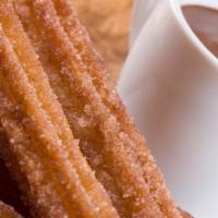 Churros Con Chocolate · Five pieces. Traditional fried dough dusted with cinnamon sugar and served with thick hot ch...