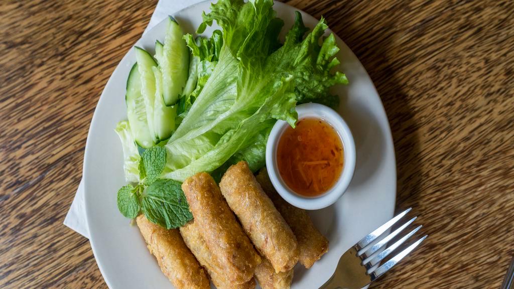 Spring Rolls · Six pieces. Long rice, potatoes, onions, carrots, and spices wrapped in crispy rice paper. Served with lettuce, cucumber, mint leaves, and chili vinegar sauce on the side.