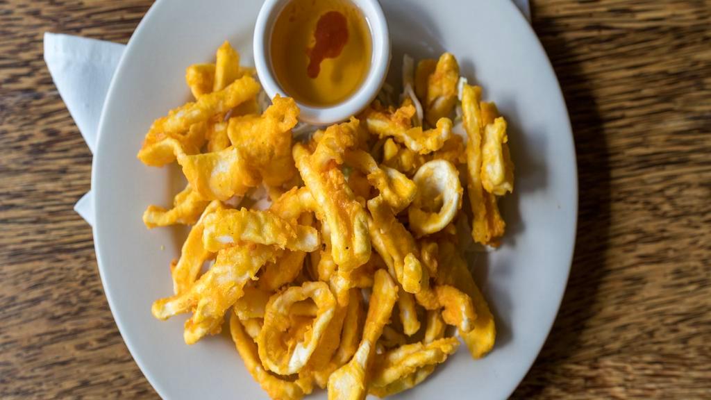 Crispy Calamari · Calamari lightly breaded with spices and served with tangy hot sauce.