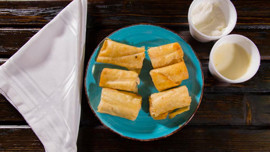 Rollitos De Pollo · Six bite-size chicken rolls deep-fried and served with nacho cheese and sour cream.