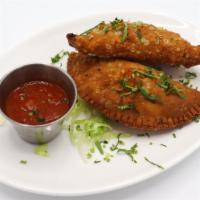 Empanadas · Two empanadas stuffed with shredded Kausa chicken or beef and cheese.