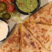 Quesadilla Appetizer · Melted cheese in between a grilled flour tortilla, sliced into 4 pieces.