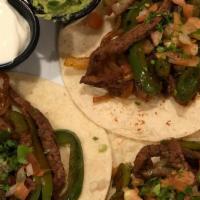 Fajita Tacos · 3 flour tortillas filled with slices of Angus steak, peppers, sautéed onions, and pico de ga...