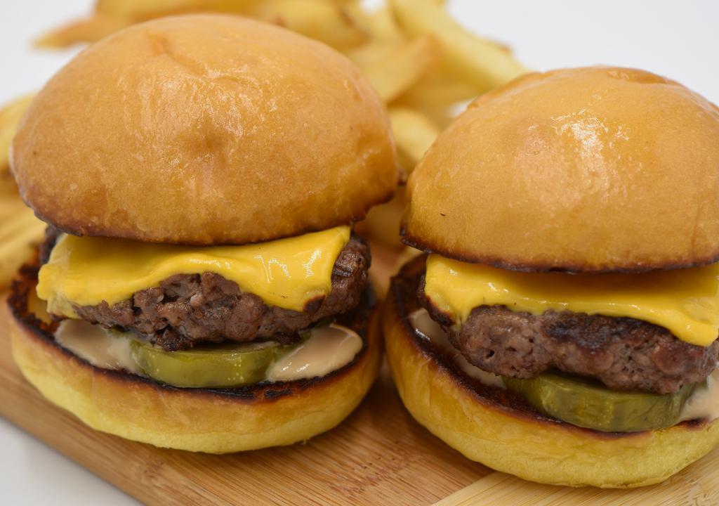 Cheeseburger Sliders · Two grilled slider buns with our Big Island beef mini patties topped with melted Cheddar cheese, pickles, and our happy mayo sauce.