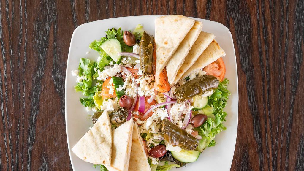 Greek Salad · Assorted salad greens, feta cheese, tomato, Greek olives, stuffed grape leaves, special Greek vinaigrette dressing served with grilled pita.
